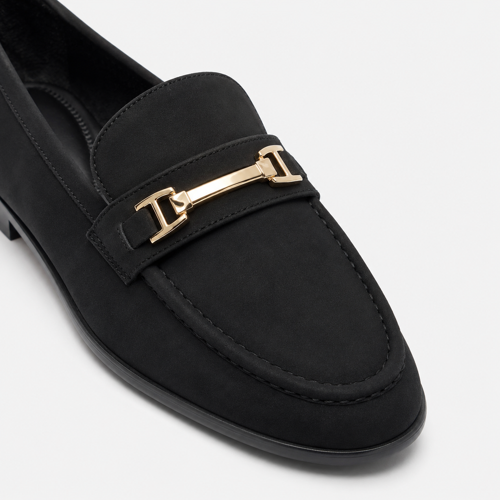Gold-tone metal hardware detail on women's black loafers