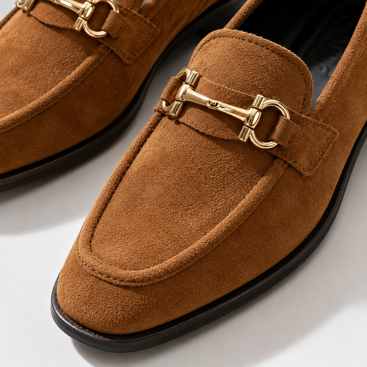 Gold-tone horsebit detail on women's brown loafers