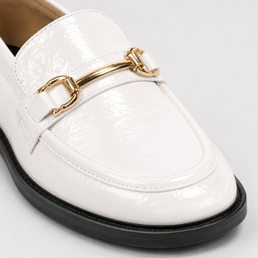 Gold-tone horsebit detail on glossy white loafers