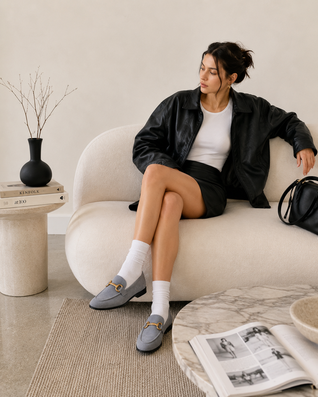 Women's gray horsebit loafers styled with a skirt